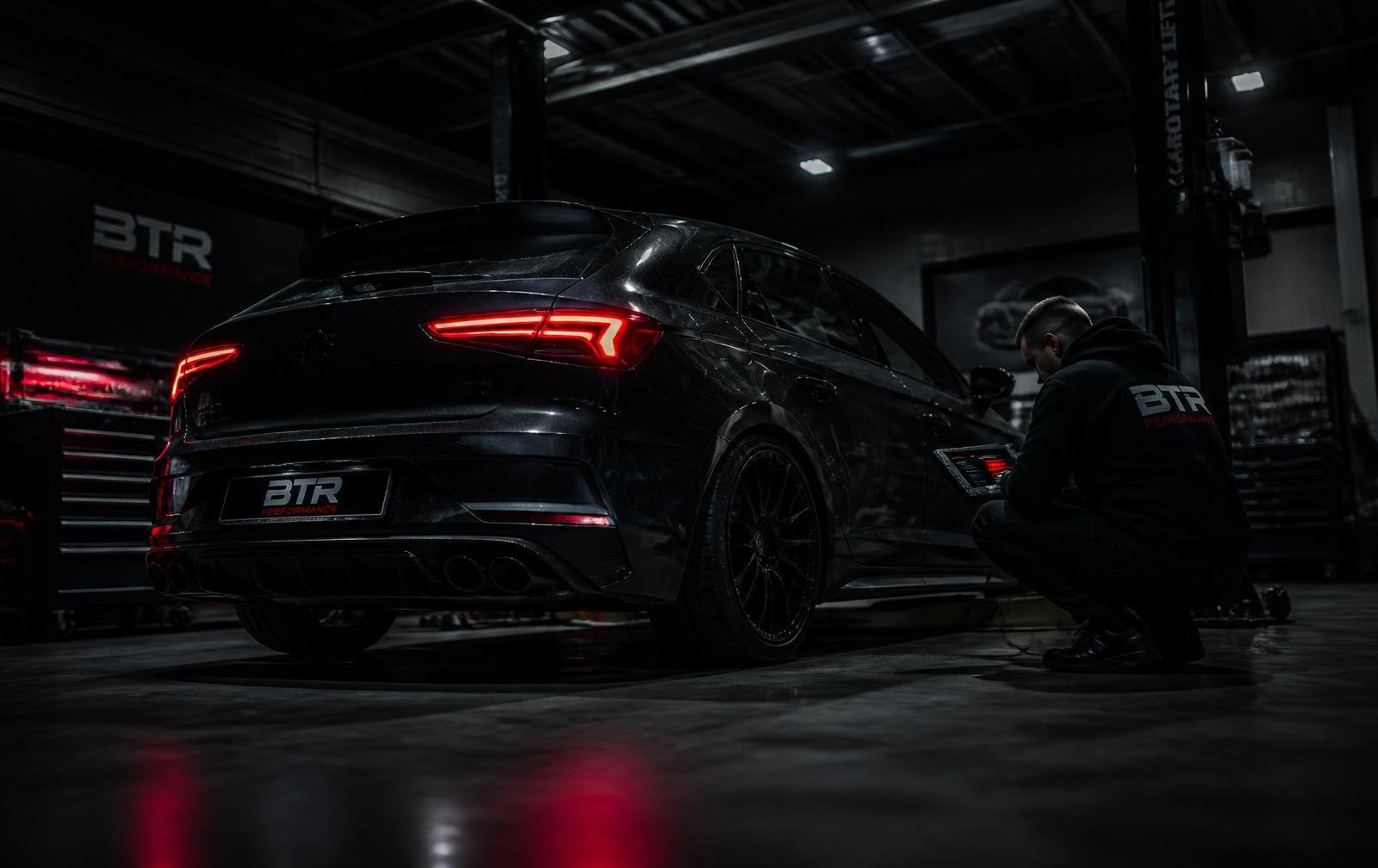 Technicien réalisant un diagnostic électronique sur une voiture dans un atelier